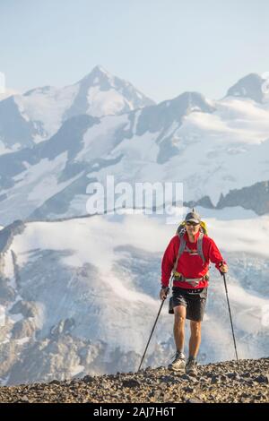 Backpacker hikes across talus slope in B.C. Canada. Stock Photo