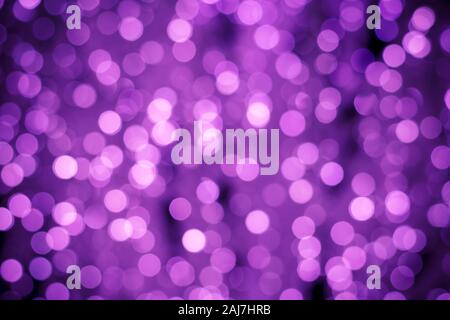 Abstract purple background with night bokeh lights. Illuminated backgrounds. Blurred backdrop, glowing texture, defocused boke. Shiny pink circles. Gl Stock Photo