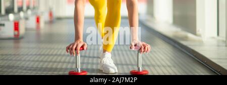 Physically fit woman at the gym with dumbbells ready to strengthen her arms and biceps Stock Photo