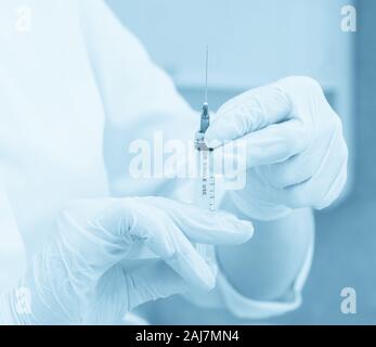 Medical healthcare. Doctor with syringe, injection in hospital, blue toning Stock Photo