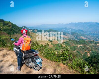 One person riding bike on Ha Giang motorbike loop, famous travel destination bikers easy riders. Ha Giang karst geopark mountain landscape in North Vi Stock Photo