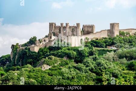 Obidos castle on the hill with green forest of trees in the foreground, Portugal. Photograph: Tony Taylor Stock Photo