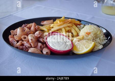 Closeup of squids with side dish on the table Stock Photo