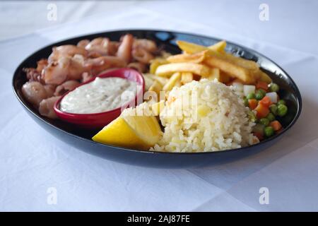 Closeup of squids with side dish on the table Stock Photo