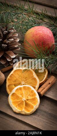 Autumnal background with dried oranges,pine and cinnamon on wood Stock Photo
