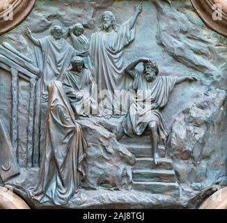 ACIREALE, ITALY - APRIL 11, 2018: The bronze relief of Resurrection of Lazarus from the gate of Basilica Collegiata di San Sebastiano . Stock Photo