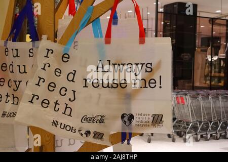 Bangkok, Thailand - January 3 2020 : Closeup and focus on words always reuse me printed on cloth bag hanging on hanger in Siam Paragon shopping mall Stock Photo