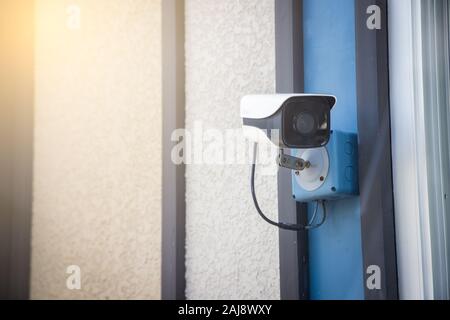 Security camera on the outdoor wall with light flare. Stock Photo