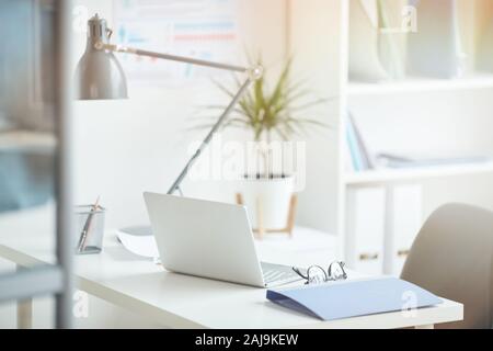 Close-up of workplace with laptop and folder on it at light modern office Stock Photo