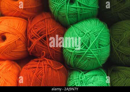Colored skeins of wool on a store shelf. Woolen skeins for knitting all the colors of the rainbow, green, brown, red and orange. Stock Photo