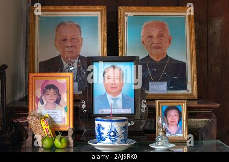 Photos of the deceased are placed on an altar with offerings in a vietnamese house Stock Photo