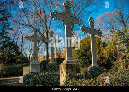 Old weathered crosses on a german graveyard in Berlin on a bright winter day Stock Photo