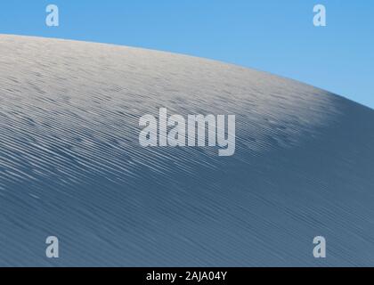 Ripples in the white sand against clear sky at White Sands National Park in New Mexico Stock Photo