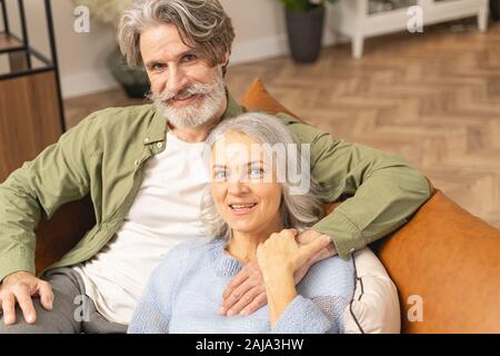Loving middle-aged man embracing his pleased wife Stock Photo