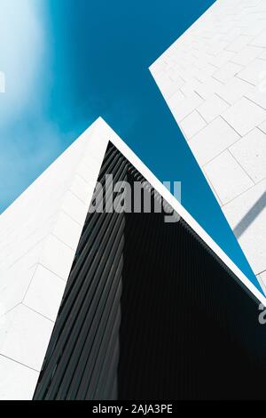 Corners of two contiguous buildings of modern architecture looking up at the sky Stock Photo