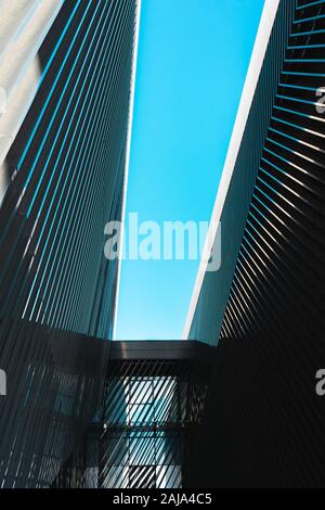 Two contiguous buildings of modern architecture looking up at the sky Stock Photo