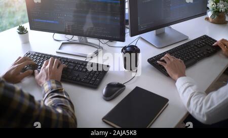 Young startup Programmers Sitting At Desks Working On Computers screen for Developing programming and coding to find solution to problem on New Applic Stock Photo