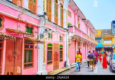 PHUKET, THAILAND - APRIL 30, 2019: The line of old bright pink Chinese Baroque edifices, decorated with stucco details, unusual windows and wall colum Stock Photo