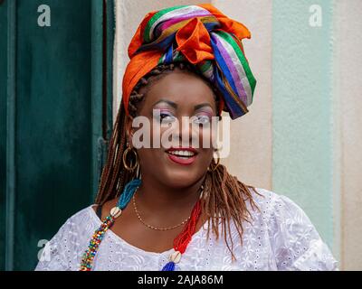 Happy Brazilian woman of African descent dressed in traditional Baiana costumes in the Historic Center of Salvador da Bahia, Brazil. Stock Photo