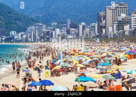 Tourists and locals enjoying the summer at famous Ipanema beach in Rio de Janeiro, Brazil. Stock Photo