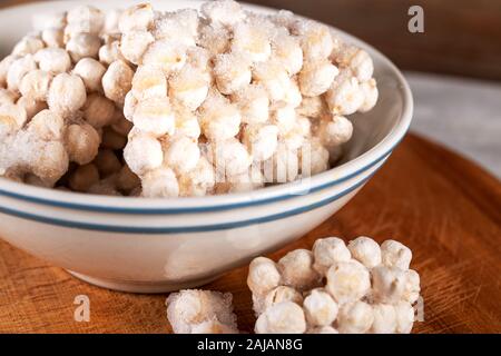 Frozen chickpeas in bowl on wooden background. Stock Photo
