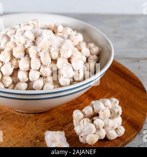 Frozen chickpeas in bowl on wooden background. Stock Photo