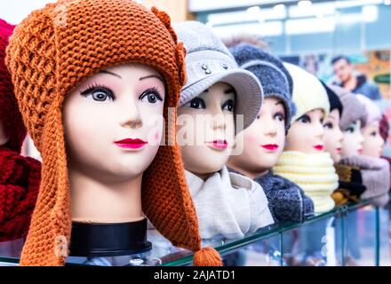 Mannequins female heads in hats and scarfs close up. Woolen knitted caps and scarves. Female headdresses Stock Photo