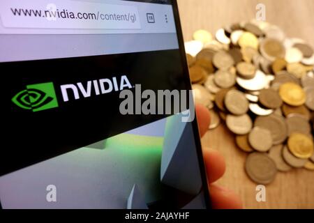 Nvidia website displayed on smartphone and stack of coins Stock Photo