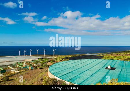 Farm landscape with wind turbines generating electricity near lighthouse Punta Teno in Tenerife, Canary islands, Spain Stock Photo