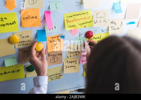 Business people write down an important note, using on the paper stickers post. Brainstorming, teamwork. Stock Photo