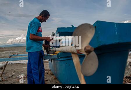 Palu City, Indonesia. 03rd Jan, 2020. A fisherman fixes a broken boat engine.High waves in the waters of Palu Bay forced Hundreds of fishermen in the village of Lere to anchor their boats. According to the Palu Meteorology, Climatology and Geophysics Agency (BMKG) the waves reached two meters to three meters, considered quite dangerous for fishermen. Credit: SOPA Images Limited/Alamy Live News Stock Photo