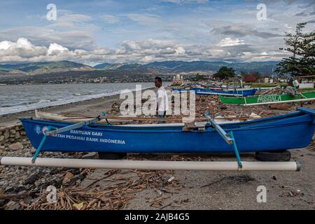 Palu City, Indonesia. 03rd Jan, 2020. A fisherman walks passed an anchored boat.High waves in the waters of Palu Bay forced Hundreds of fishermen in the village of Lere to anchor their boats. According to the Palu Meteorology, Climatology and Geophysics Agency (BMKG) the waves reached two meters to three meters, considered quite dangerous for fishermen. Credit: SOPA Images Limited/Alamy Live News Stock Photo