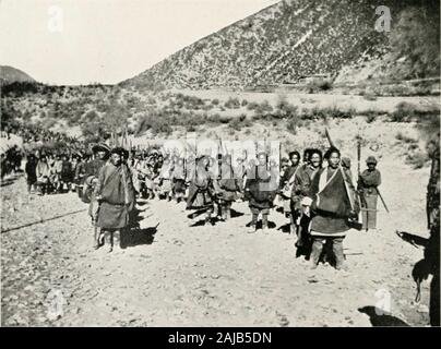 Travels of a consular officer in eastern Tibet : together with a history of the relations between China, Tibet and India . SUNRISE ON THE PEAKS OF THE MEKONG-SALWEEN DIVIDE IN SOUTHERN KAM. TRIBESMEN OF KAM IN ARMS Ill CHAO ERH-FENG AS FRONTIER COMMISSIONER 23 the capital of Szcchuan, where he was received in state as avictorious general, and was subsequently granted the Batarudecoration, the Manchu Order of Merit, by the Emperor.He had shortly before been appointed to the newly createdpost of Frontier Commissioner (Pioi-wu Ta-chen), with therank of Vice-President of a Peking Board, the appoin Stock Photo