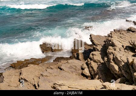 Breaking waves on rocky coast Stock Photo