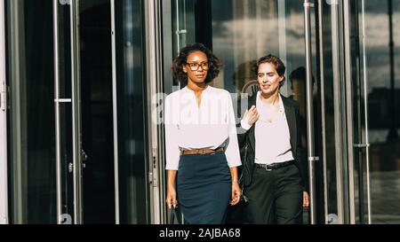 Two women out office building. Business colleagues walking together. Stock Photo