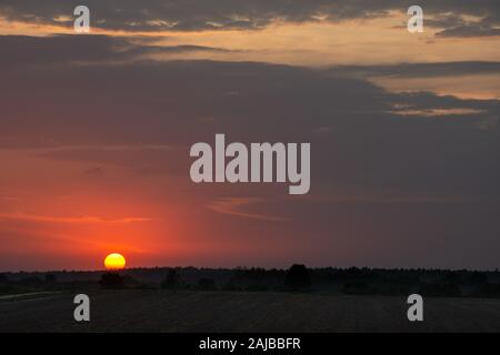 Beautiful purple sunset with clouds above the horizon Stock Photo