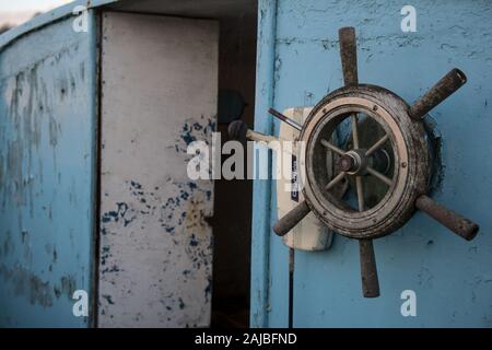 Aberystwyth Ceredigion Wales, UK January 03 2020: Close up of a small ship wooden navigation steering wheel with a blue background Stock Photo