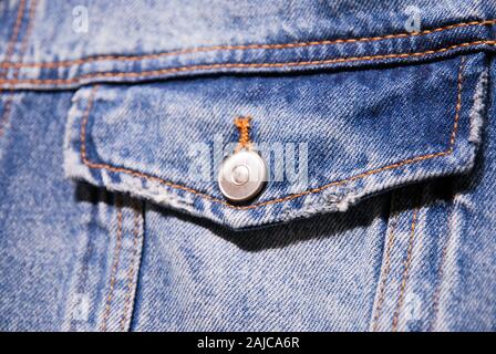 close-up of chest pocket of denim jacket with flap and metal button Stock Photo