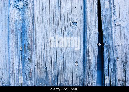Old blue painted wooden fence with rusty nails and slit Stock Photo