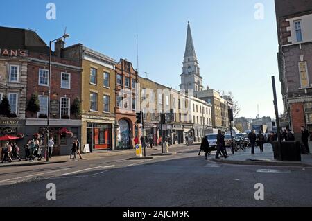 Street view of people walking on Commercial Street and the spire of Christ Church building in Spitalfields East London E1 England UK  KATHY DEWITT Stock Photo