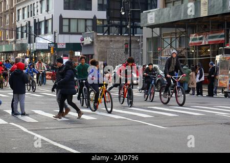 A 'wheelie crew' of young people of color riding bikes en masse in New York City (December 31, 2019) Stock Photo