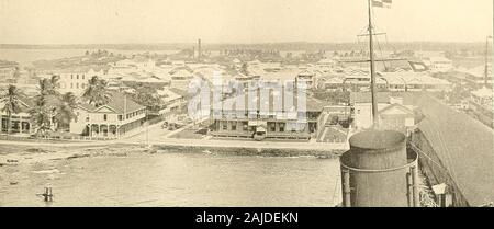 Panama and the canal in picture and prose .. . «E---^, III. colon: PANAMA RAILROAD AND ROYAL MAIL DOCKS ATLANTIC BEGINNING OF THE CANAL T73. II. colon: part of the residential district on the water front and the Aquitania at the time of theirlaunching. From the shore of the bay to the first Gatun lockis a little less than four miles. The French dug acanal penetrating this section, a canal which formstoday part of our harbor and which has been usedto some extent for the transportation of material forthe Gatun dam. Our engineers however abandoned it as part of our permanent line, and it is rapid Stock Photo