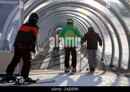 Skiers on a covered magic carpet on the learner's slope aka Bunny slope at Mont-Orford Ski Resort. Mont-Orford National Park.Orford.Quebec.Canada Stock Photo