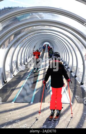 Skiers on a covered magic carpet on the learner's slope aka Bunny slope at Mont-Orford Ski Resort. Mont-Orford National Park.Orford.Quebec.Canada Stock Photo