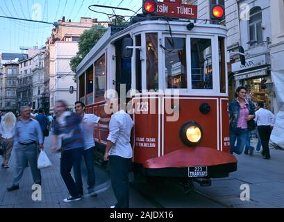 Istanbul / Turkey - May 25, 2010: Woman hanging on iconic vintage red tram vehicle that runs from Taksim to Tunnel. Stock Photo