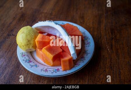Tropical fruits plate on the table: guava, papaya, and coconut Stock Photo