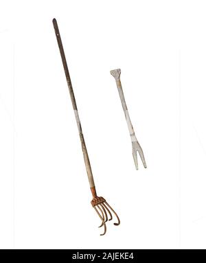 Old-fashioned rusty and well-used tools and farm equipment, isolated on a white background Stock Photo