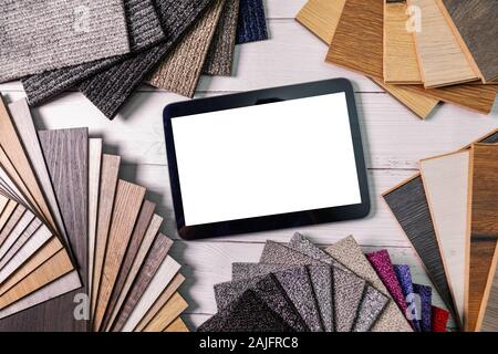 flooring and furniture materials - floor carpet and wooden laminate samples with blank digital tablet Stock Photo
