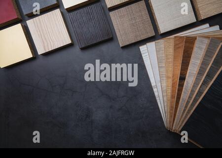 wood texture laminate furniture and flooring material samples on dark stone background with copy space Stock Photo