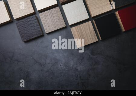 wood texture laminate furniture material samples on dark stone background with copy space Stock Photo